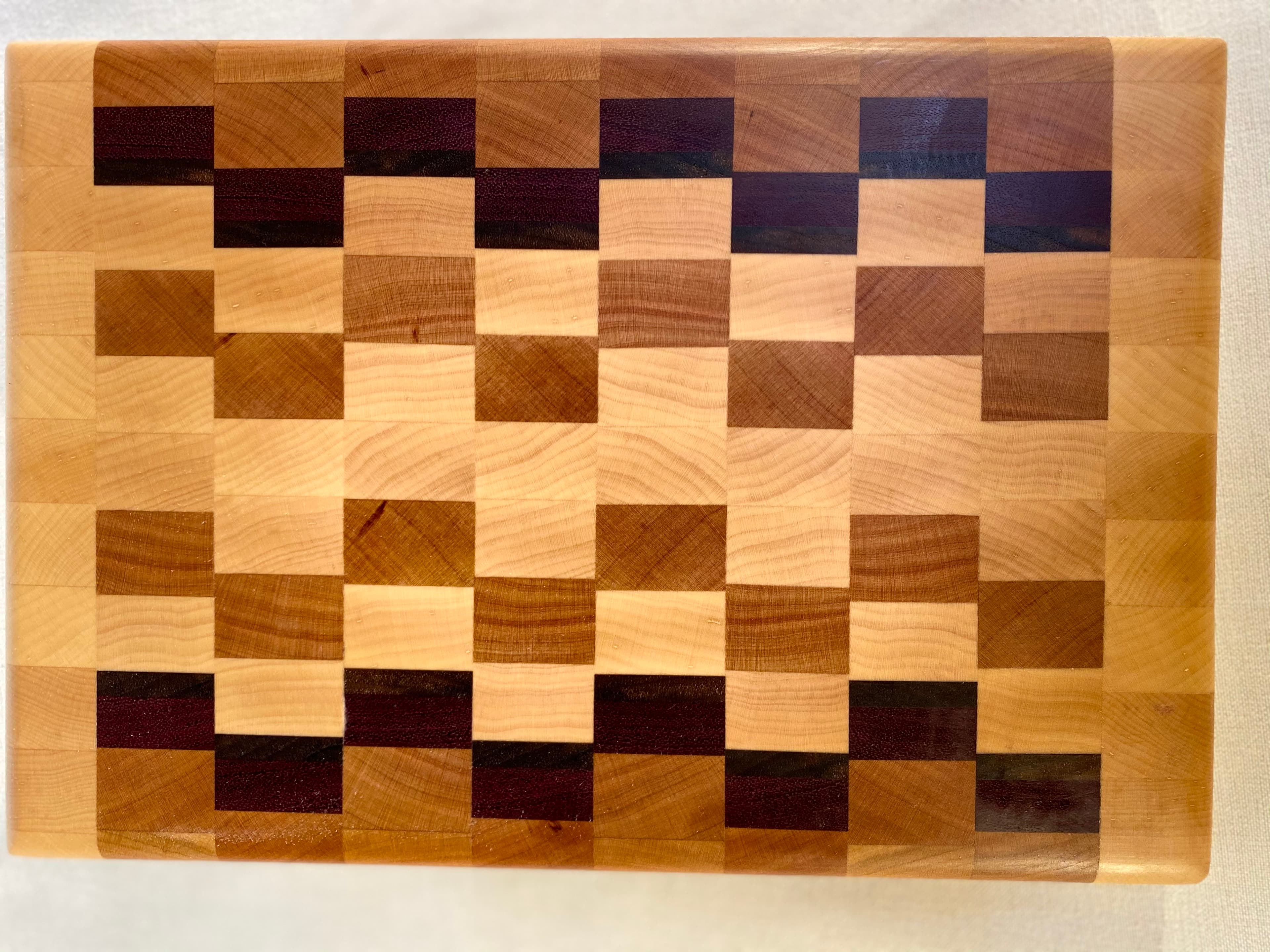 End grain cutting board with patterned wood blocks